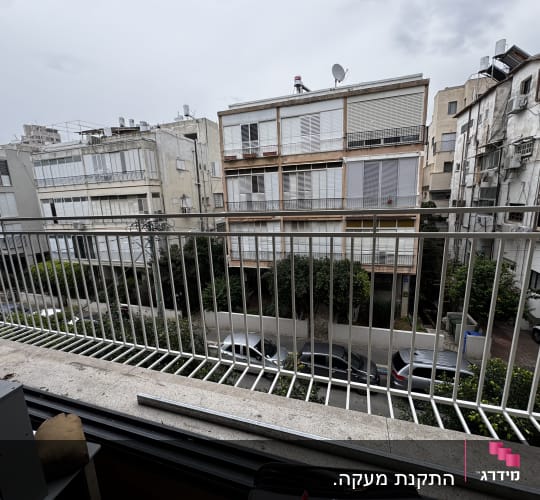 מעקה מתכת במרפסת עם נוף לבניינים